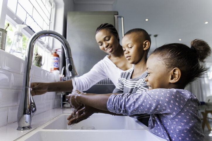 Family washing their hands together. family-washing-their-hands-together
